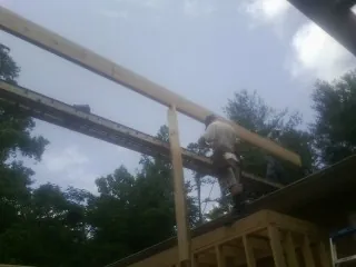 Carpenter setting a ridge beam over a new addition frame — Ice Dam Removal by Roofing Brothers in East Grand Forks